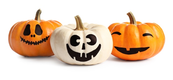 Photo of Halloween pumpkins with cute drawn faces on white background