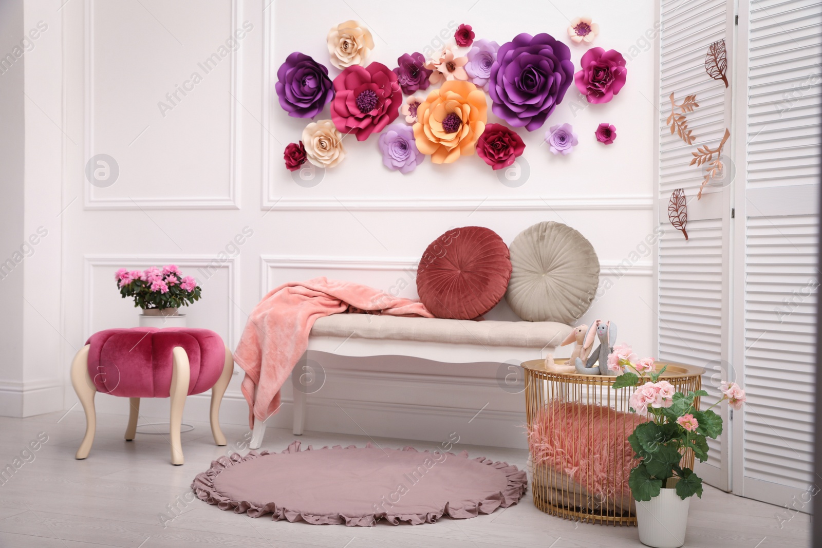 Photo of Elegant Easter photo zone with paper flowers and bench indoors