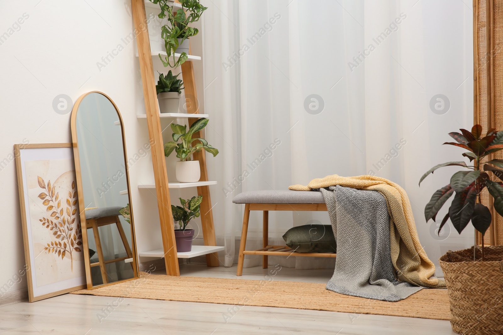 Photo of Room interior with wooden furniture, mirror and houseplants. Stylish accessories