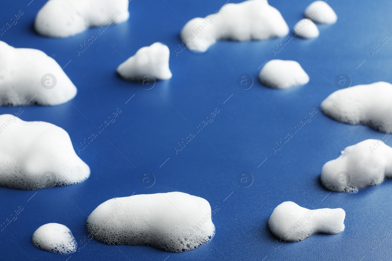 Photo of Drops of soap foam on color background. Space for text