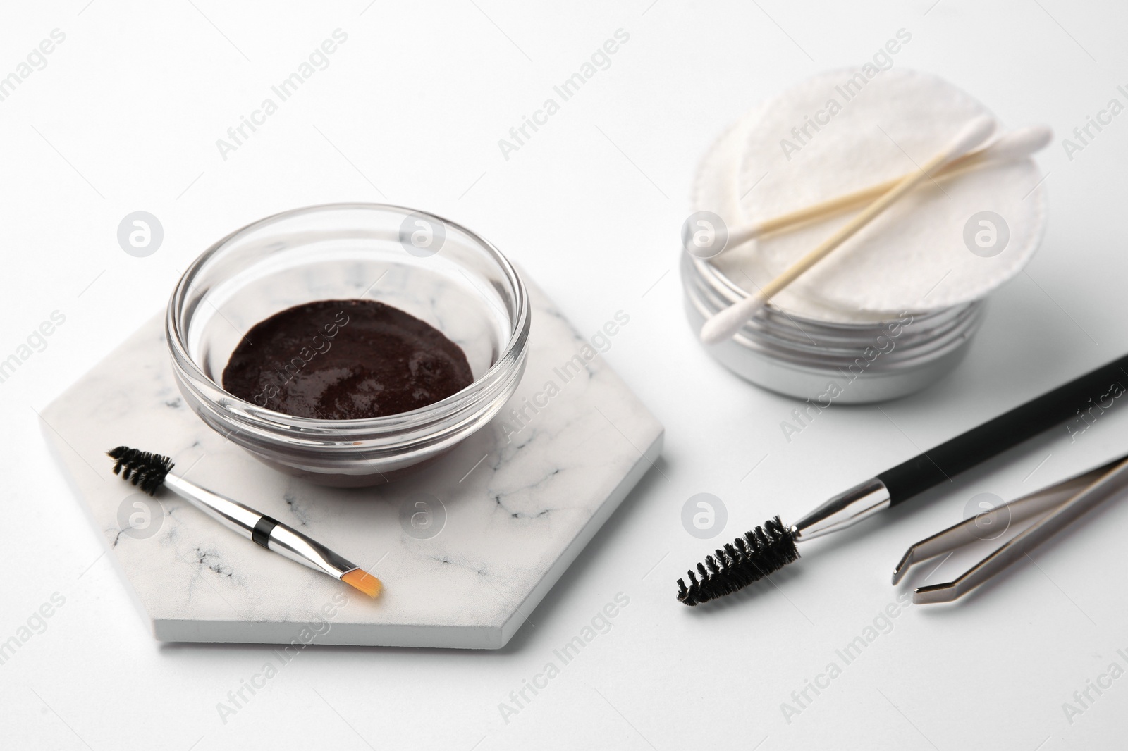 Photo of Eyebrow henna and professional tools on white background, closeup