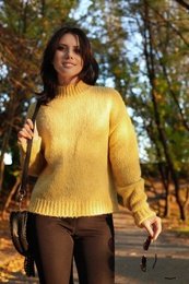 Photo of Beautiful young woman wearing stylish sweater in autumn park