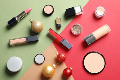 Photo of Flat lay composition with makeup products and Christmas decor on color background