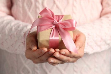 Photo of Woman holding gift box with pink bow, closeup