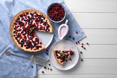 Delicious currant pie and fresh berries on white wooden table, flat lay. Space for text