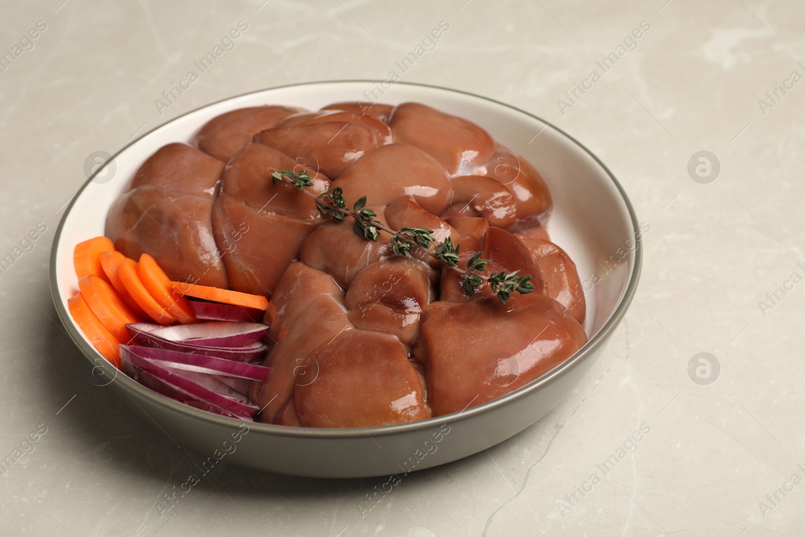 Photo of Fresh raw kidney meat with vegetables on light grey table