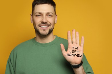 Image of Left-handed man with open palm with text on yellow background