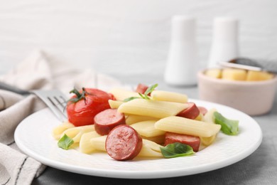 Tasty pasta with smoked sausage, tomato and basil on table, closeup. Space for text