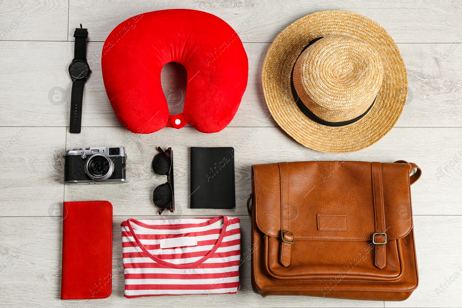 Photo of Flat lay composition with travel pillow and tourist stuff on wooden floor