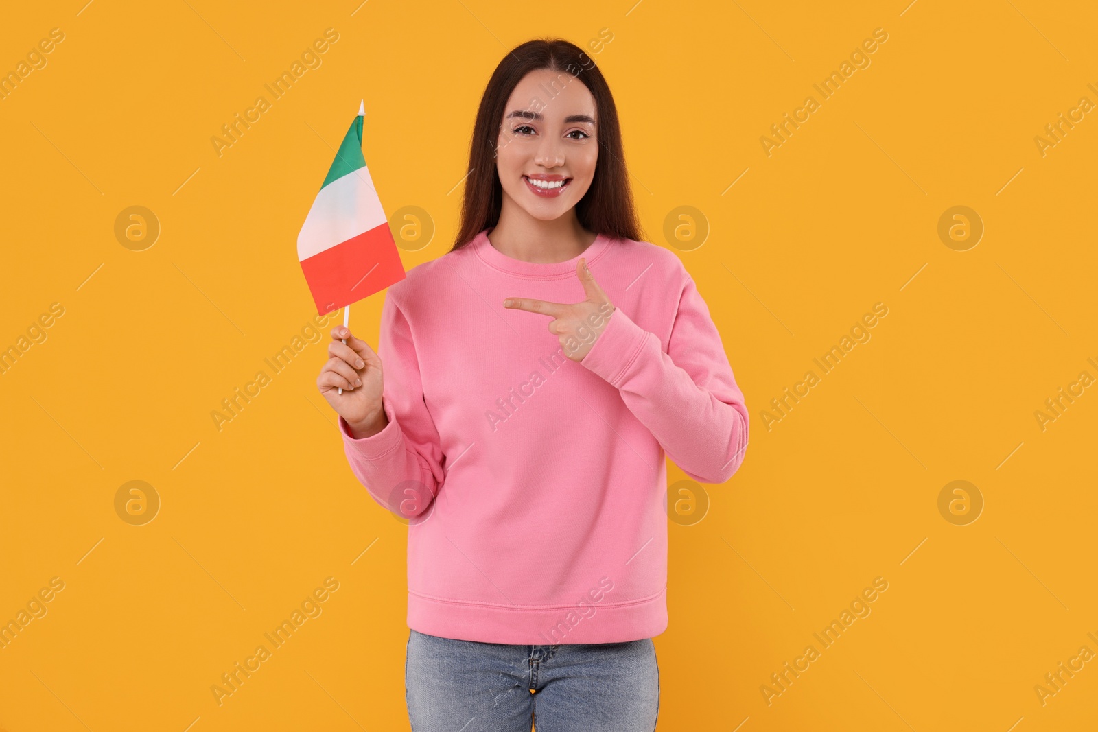 Photo of Young woman holding flag of Italy on orange background