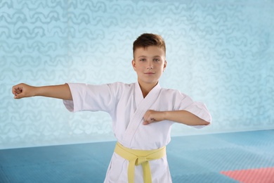 Photo of Boy in kimono practicing karate at gym