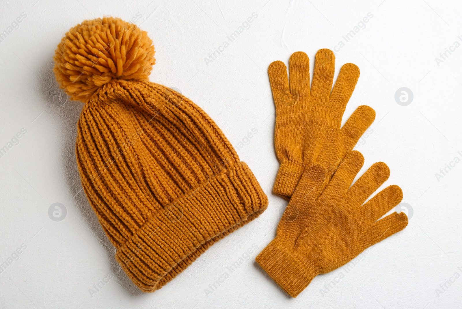 Photo of Stylish gloves and hat on white background, flat lay