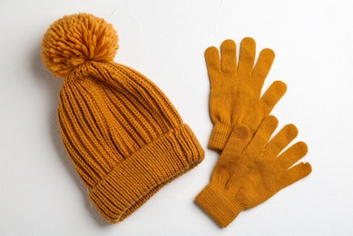 Stylish gloves and hat on white background, flat lay