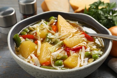 Photo of Bowl of delicious turnip soup on grey table, closeup