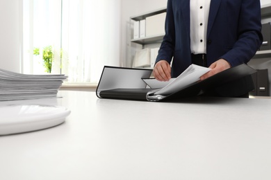 Woman working with documents at table in office, closeup