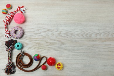 Photo of Flat lay composition with dog leash and toys on white wooden background, space for text