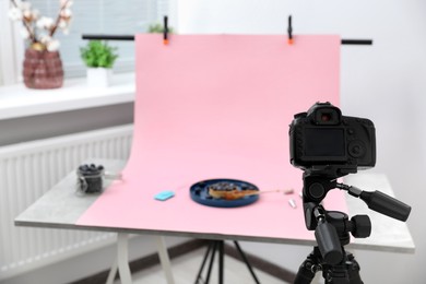 Photo of Professional equipment and composition with delicious dessert on pink background in studio. Food photography