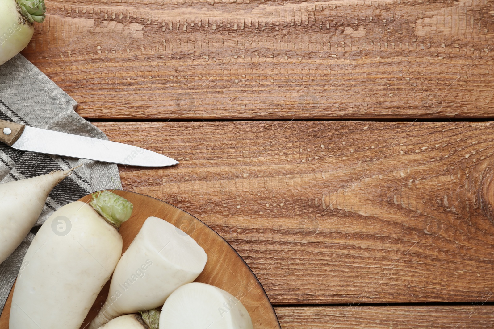 Photo of White turnips on wooden table, flat lay. Space for text