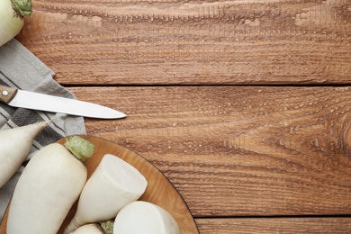 Photo of White turnips on wooden table, flat lay. Space for text