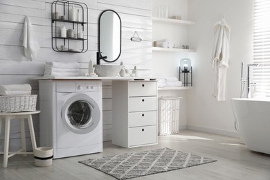 Photo of Stylish bathroom interior with modern washing machine