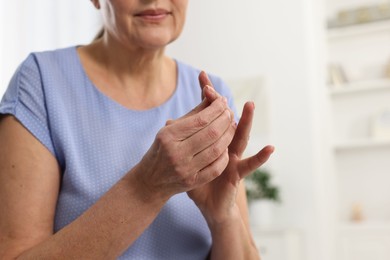 Photo of Arthritis symptoms. Woman suffering from pain in finger at home, selective focus