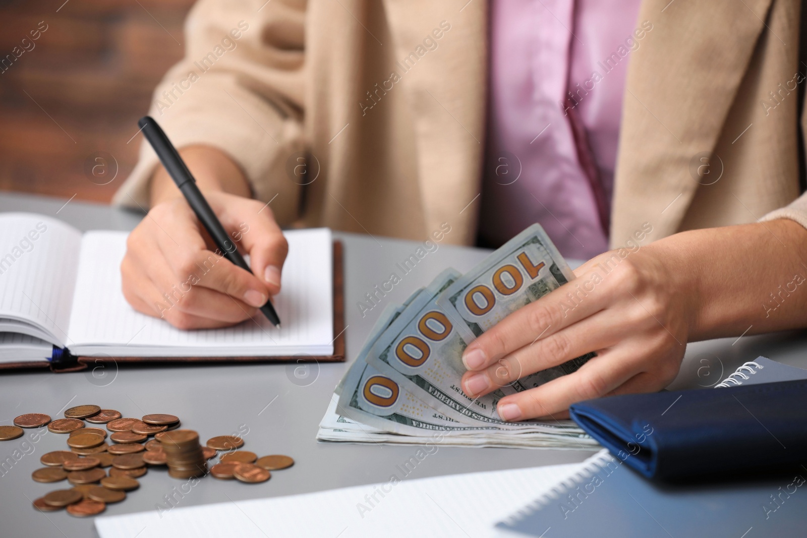 Photo of Woman counting American money at table indoors, closeup