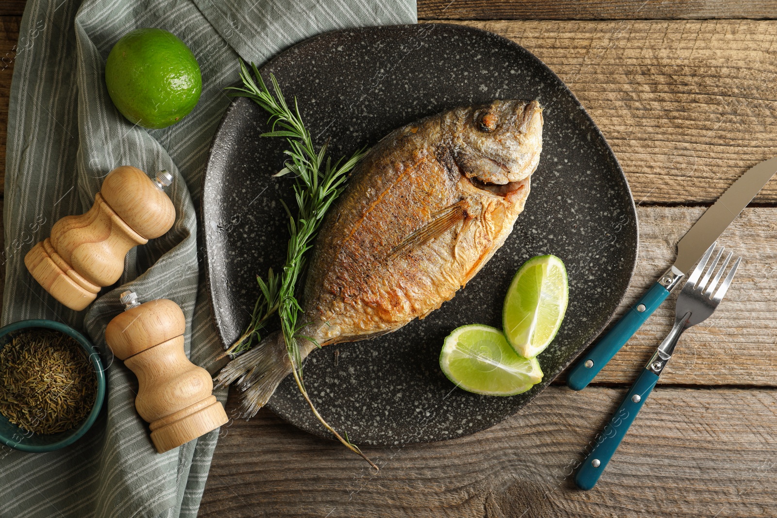 Photo of Delicious dorado fish served on wooden table, flat lay