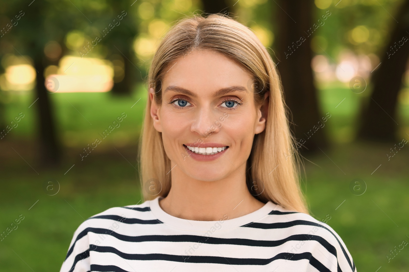 Photo of Portrait of happy woman in casual clothes outdoors. Attractive lady smiling and looking into camera