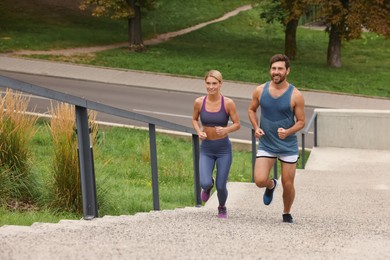 Healthy lifestyle. Happy couple running up stairs outdoors