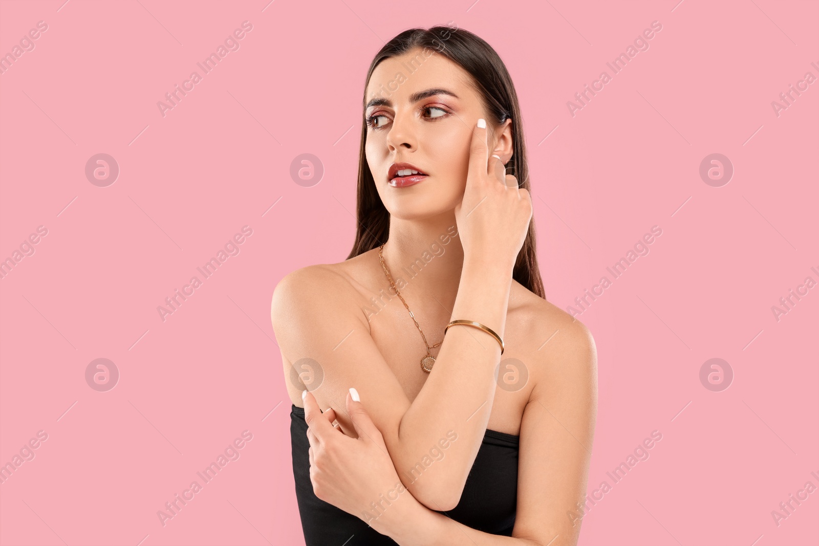 Photo of Beautiful woman with elegant jewelry on pink background, space for text