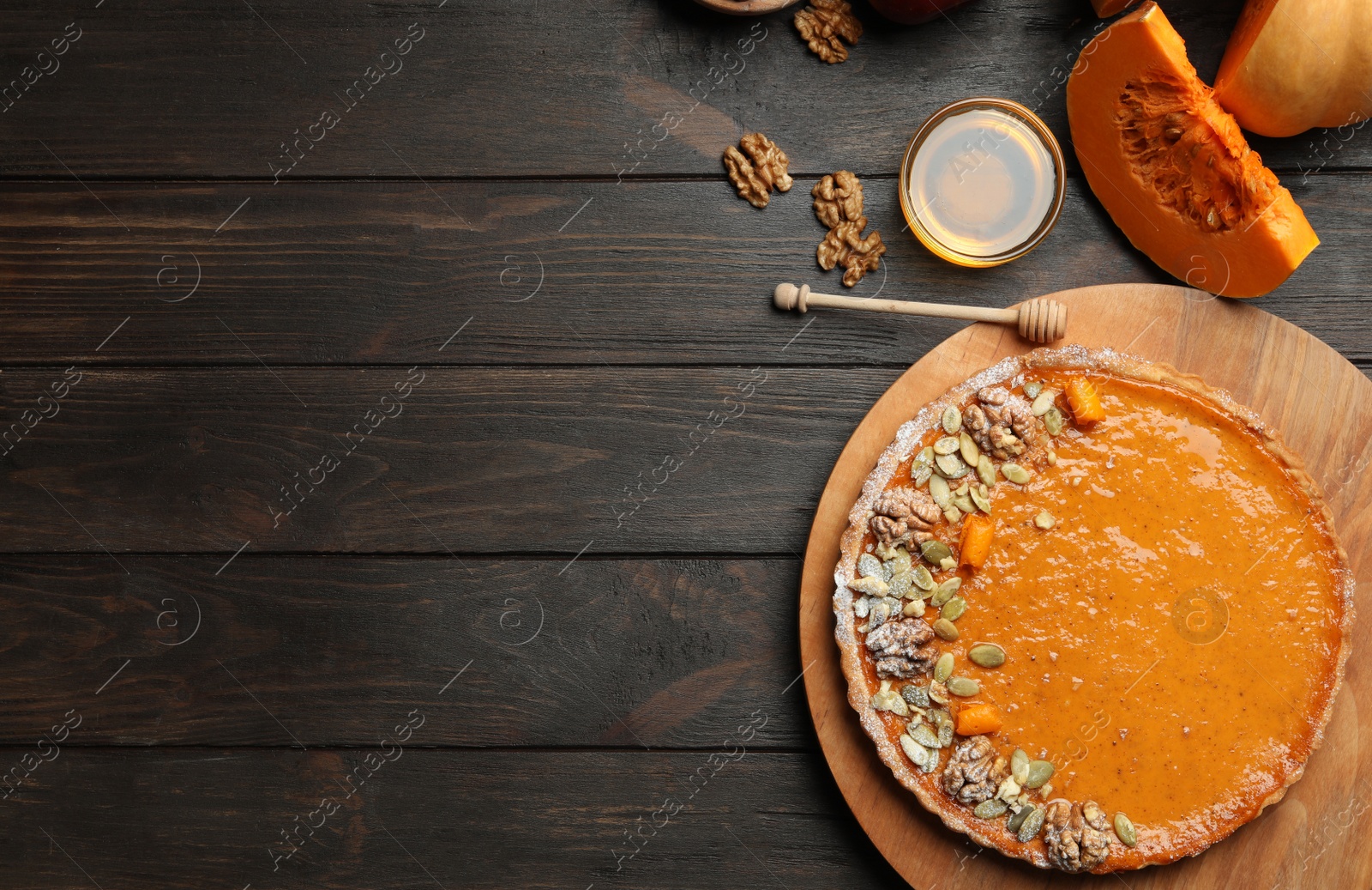 Photo of Flat lay composition with delicious fresh homemade pumpkin pie on dark wooden table. Space for text