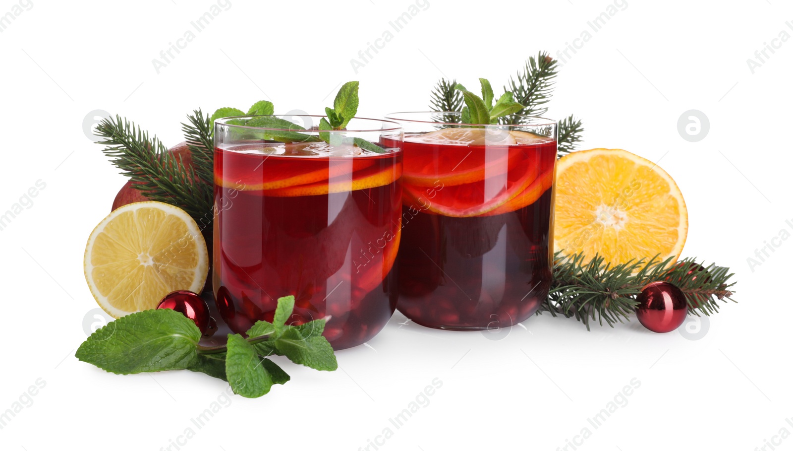Photo of Christmas Sangria drink in glasses, fir branches, fruits and baubles on white background