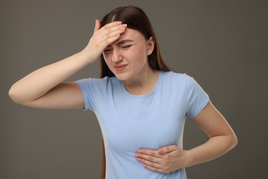 Woman having heart attack on grey background