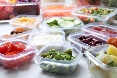 Photo of Set of containers with fresh food on white table