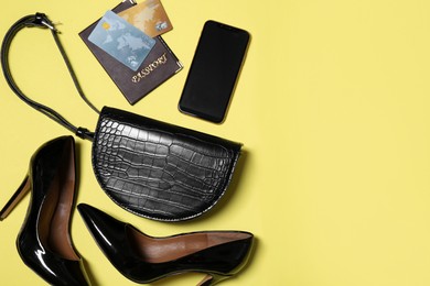 Flat lay composition with stylish woman's bag on yellow background. Space for text