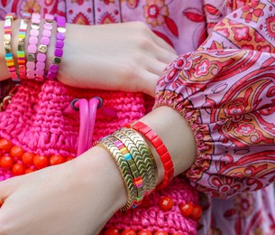 Photo of Woman with stylish purse wearing bracelets outdoors, closeup