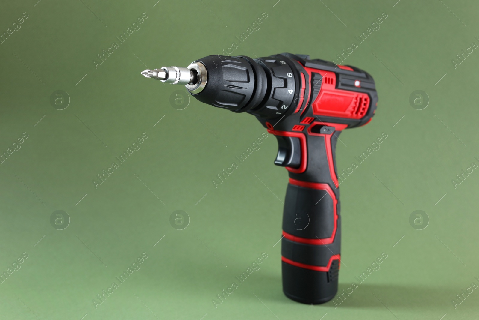 Photo of Modern electric screwdriver on pale green background