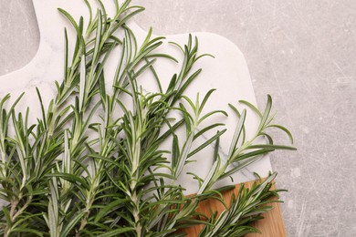Photo of Sprigs of fresh rosemary on light grey table, top view