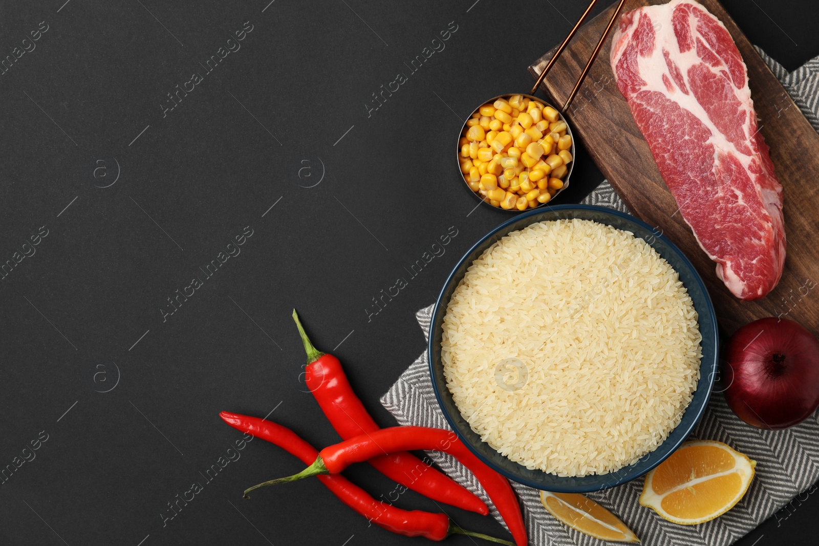 Photo of Flat lay composition with different ingredients on black background, space for text. Risotto recipe