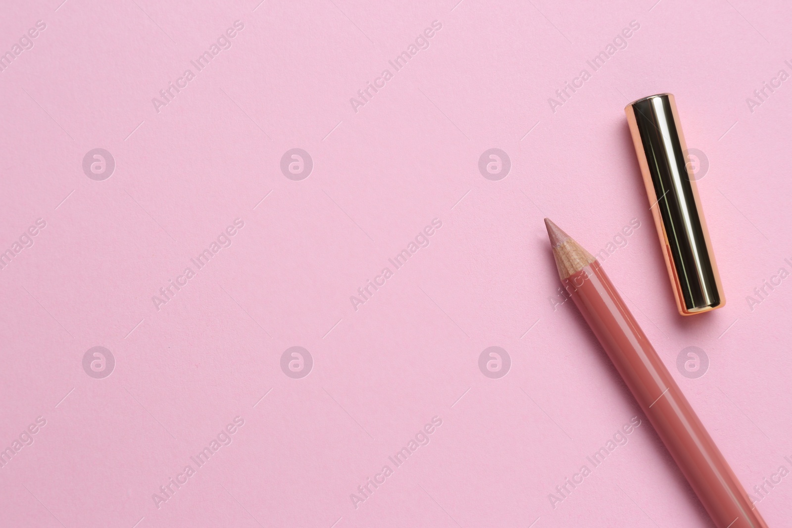 Photo of Lip pencil on pink background, flat lay with space for text. Cosmetic product