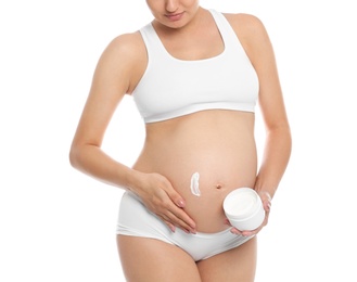 Photo of Pregnant woman applying body cream on belly against white background, closeup