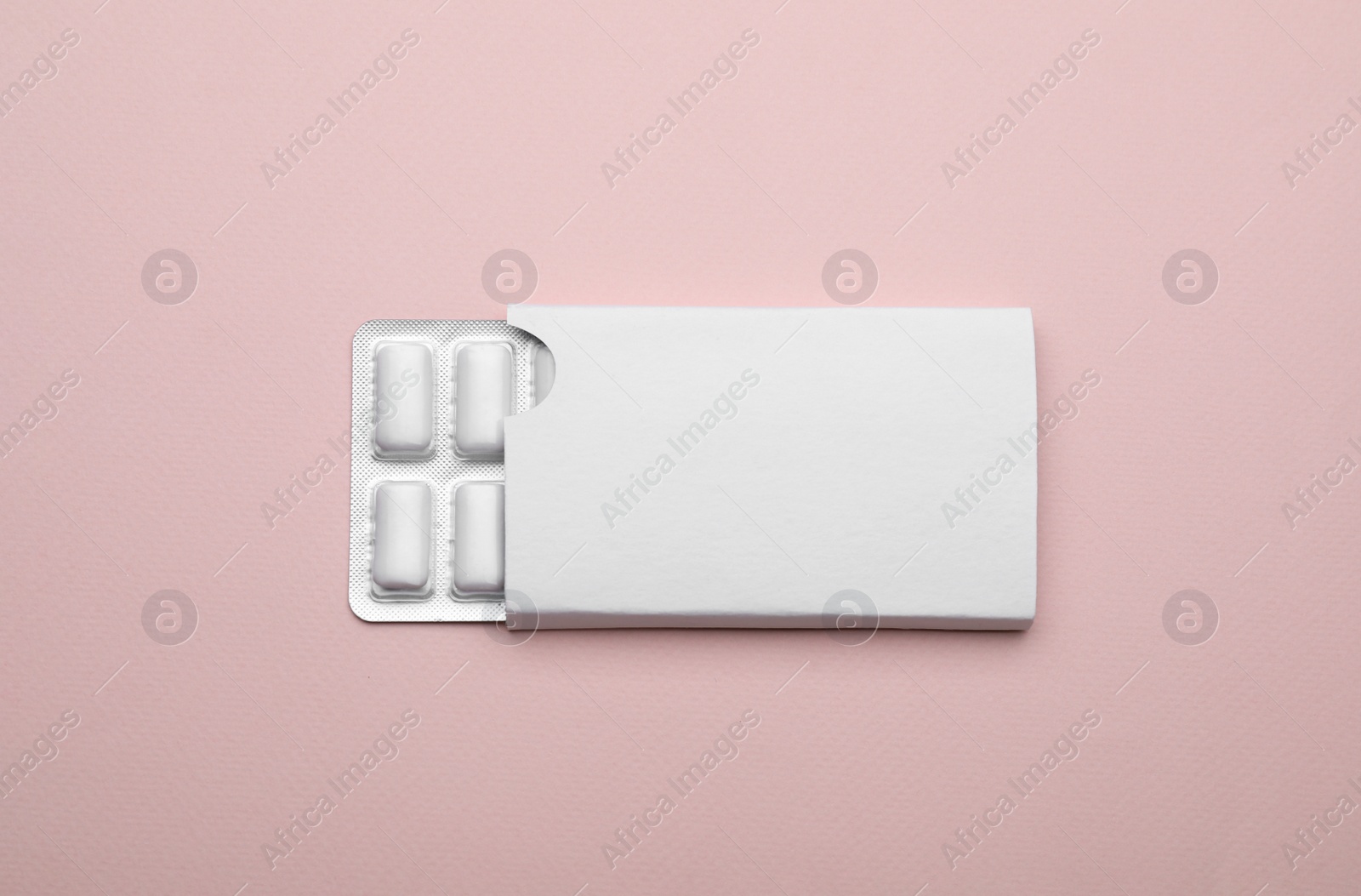 Photo of Blister with chewing gums on pink background, top view