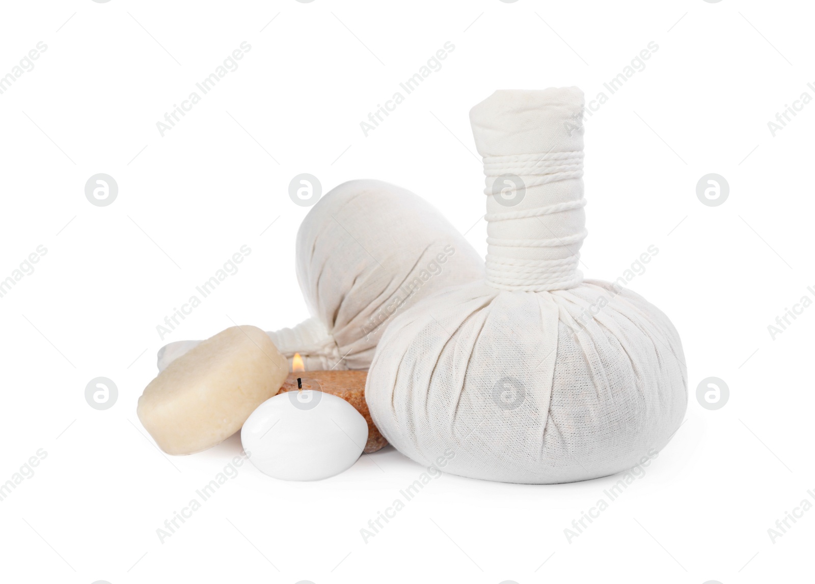 Photo of Herbal massage bags, soap and candle on white background. Spa supply