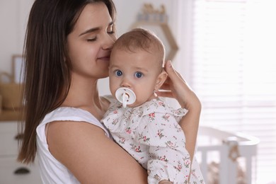 Photo of Happy young mother with her baby daughter at home