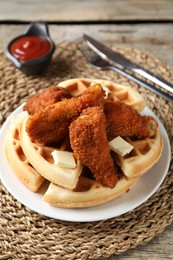 Delicious Belgium waffles served with fried chicken and butter on wooden table, closeup