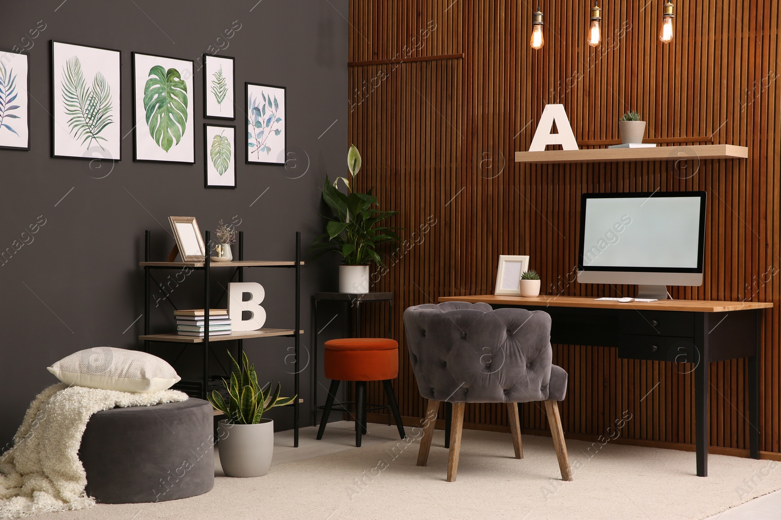 Photo of Comfortable workplace with computer near wooden wall in stylish room interior. Home office design