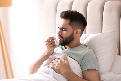 Photo of Man suffering from runny nose in bed