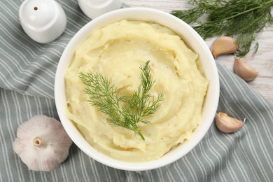 Photo of Bowl of tasty mashed potato with garlic and dill on table, flat lay