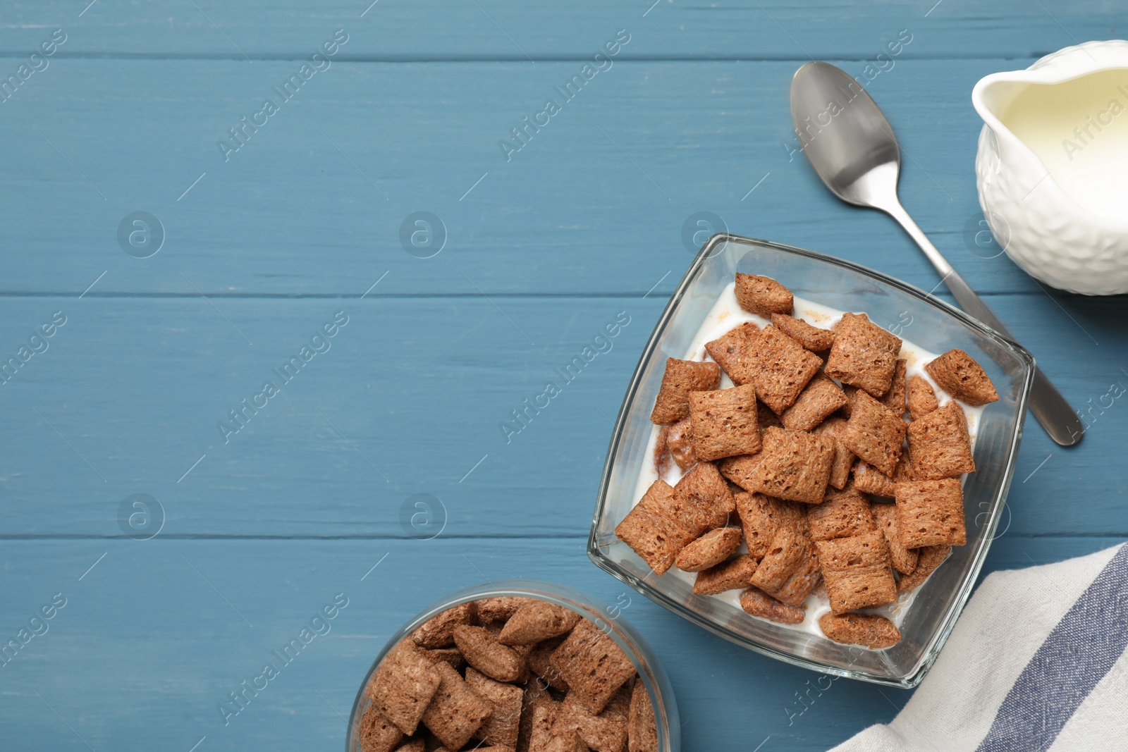 Photo of Tasty corn pads with milk served on light blue wooden table, flat lay. Space for text