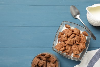 Photo of Tasty corn pads with milk served on light blue wooden table, flat lay. Space for text